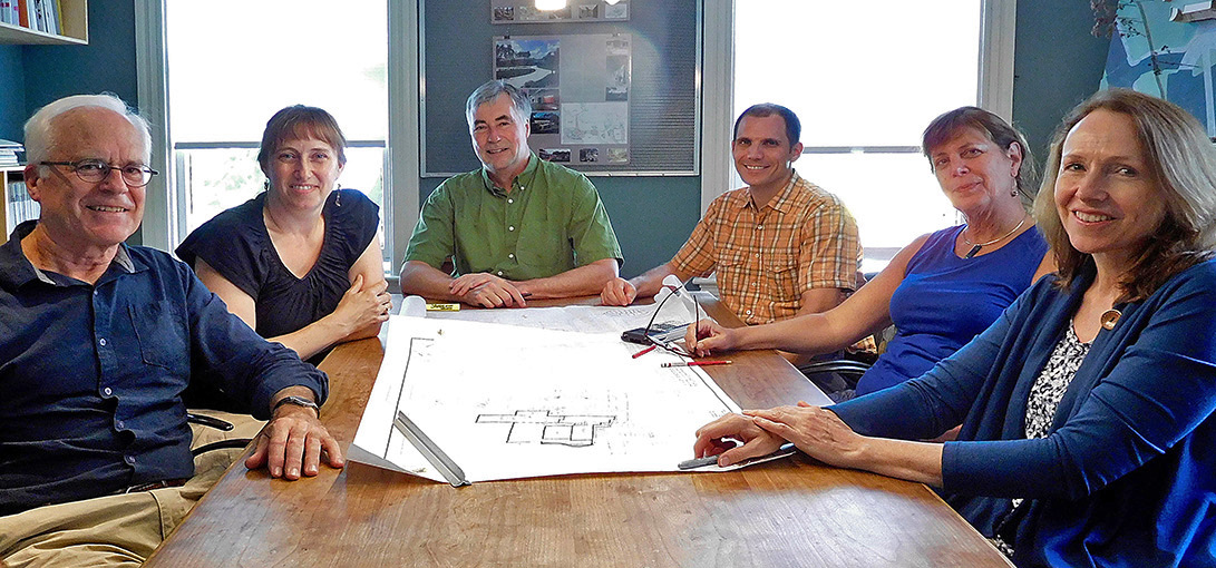 Color photo of Whipple Callender Architects staff sitting around conference room table